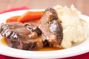 Plate of pot roast with mashed potatoes and carrots